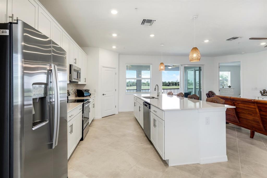 14180 Poppy Fld Loop Punta Gorda, FL 33955 - Photo 11 of 30 a large kitchen with stainless steel appliances lots of counter space and a refrigerator