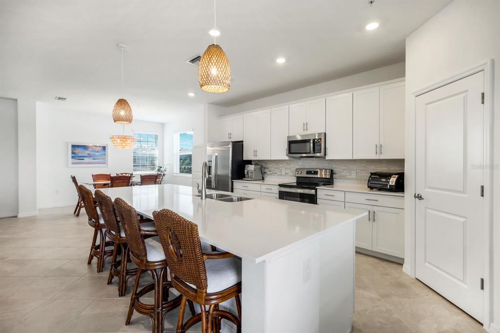 14180 Poppy Fld Loop Punta Gorda, FL 33955 - Photo 12 of 30 a kitchen with a dining table chairs and refrigerator
