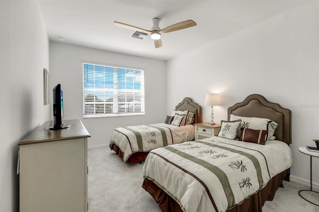 14180 Poppy Fld Loop Punta Gorda, FL 33955 - Photo 17 of 30 a bedroom with two beds and a chandelier