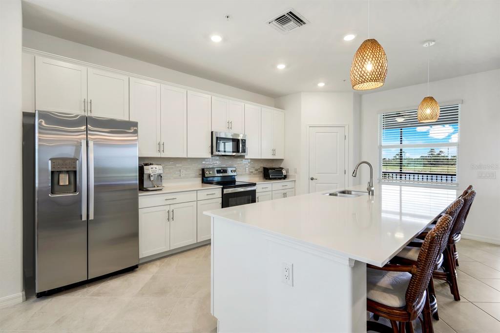 14180 Poppy Fld Loop Punta Gorda, FL 33955 - Photo 9 of 30 a kitchen with refrigerator a sink a stove and a chandelier