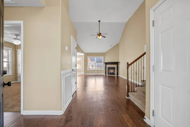 a view of a hallway with wooden floor and a livingroom