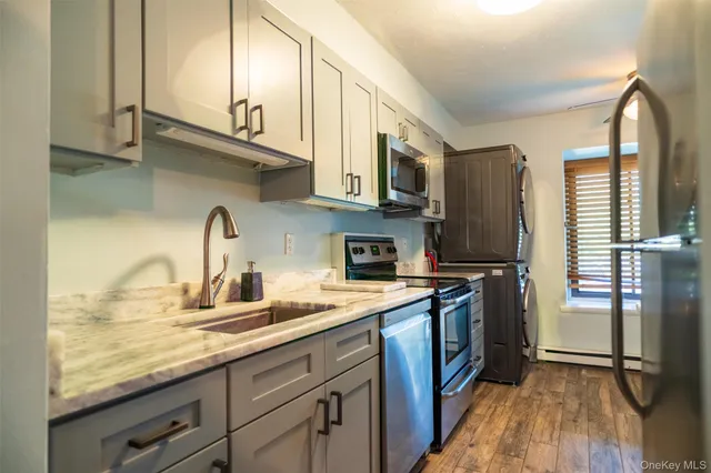 a kitchen with stainless steel appliances granite countertop a sink a stove and a refrigerator
