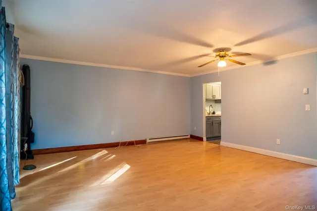 an empty room with windows and fan