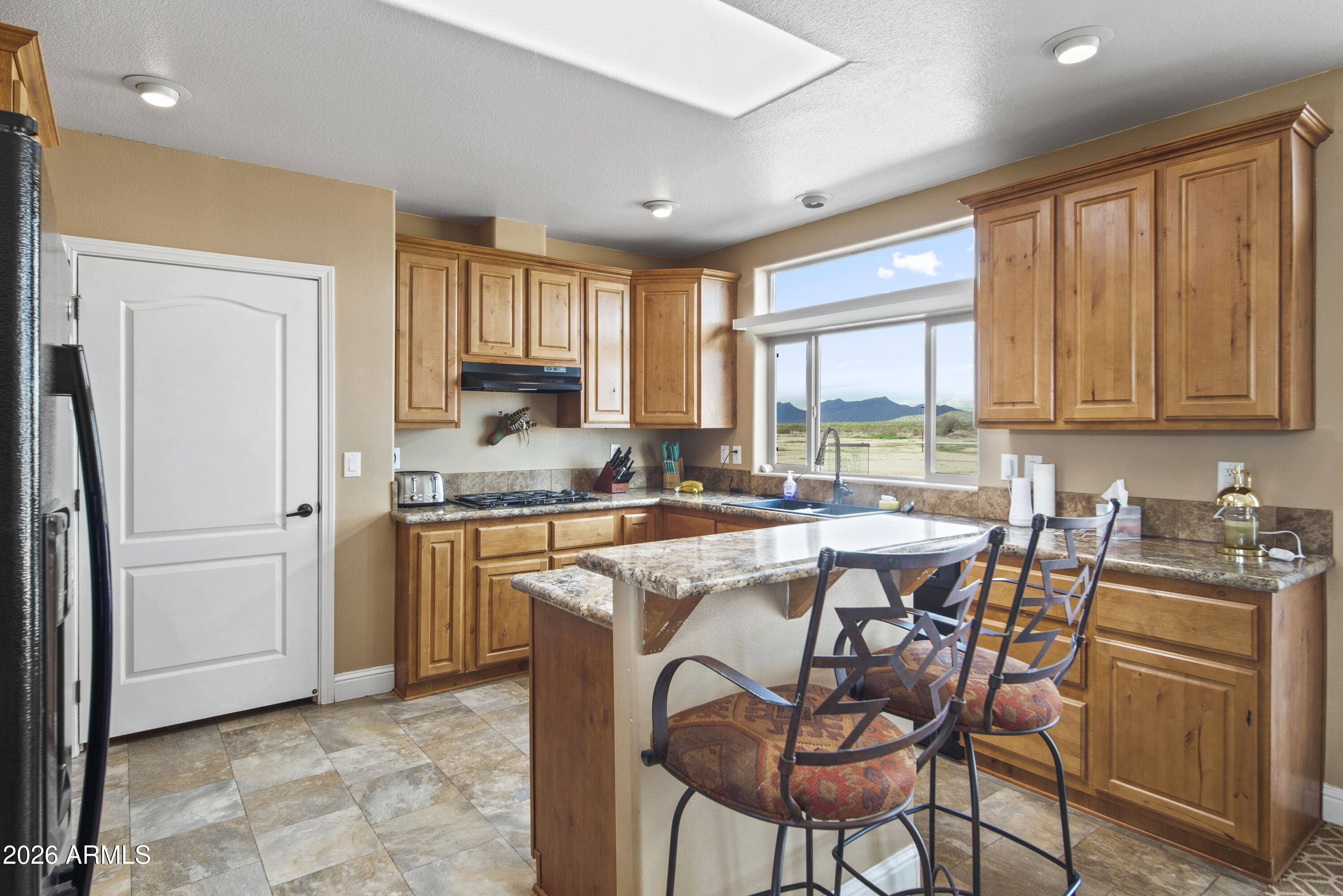 46109 West J-1 Ranch Road Wickenburg, AZ 85390 - Photo 16 of 32 a kitchen with stainless steel appliances granite countertop a stove a sink refrigerator and a microwave