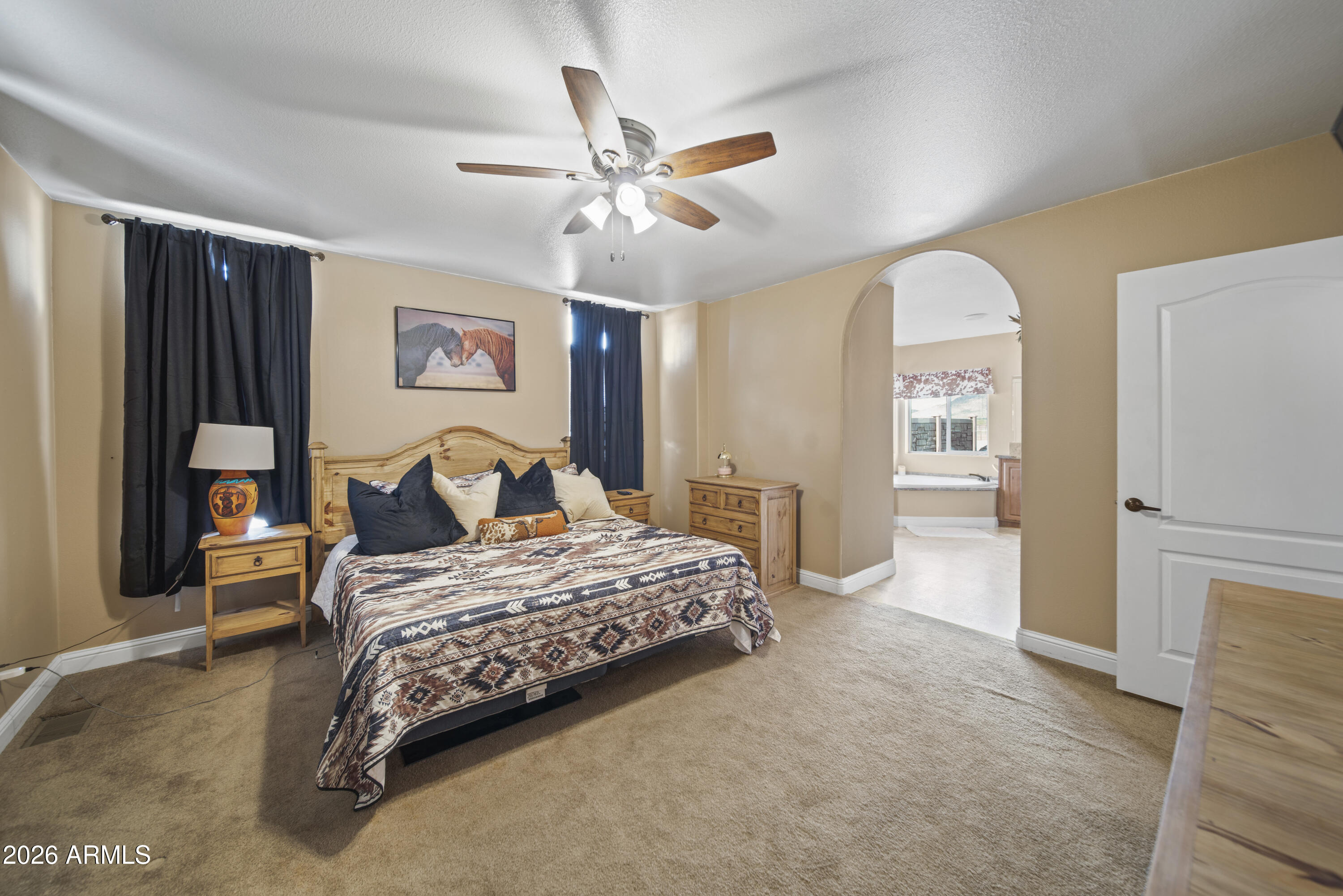 46109 West J-1 Ranch Road Wickenburg, AZ 85390 - Photo 19 of 32 a bedroom with a bed and a chandelier