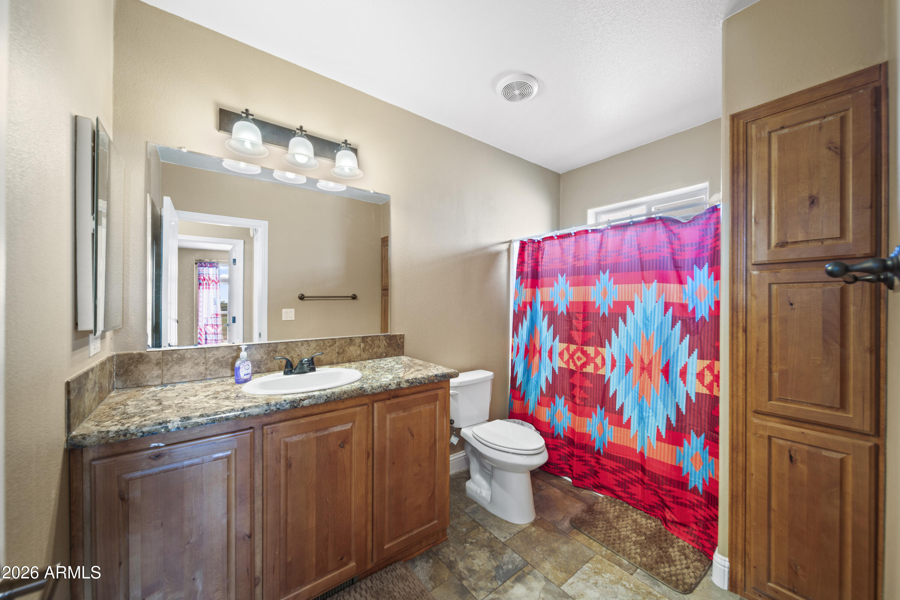 46109 West J-1 Ranch Road Wickenburg, AZ 85390 - Photo 24 of 32 a bathroom with a granite countertop sink a toilet and a mirror