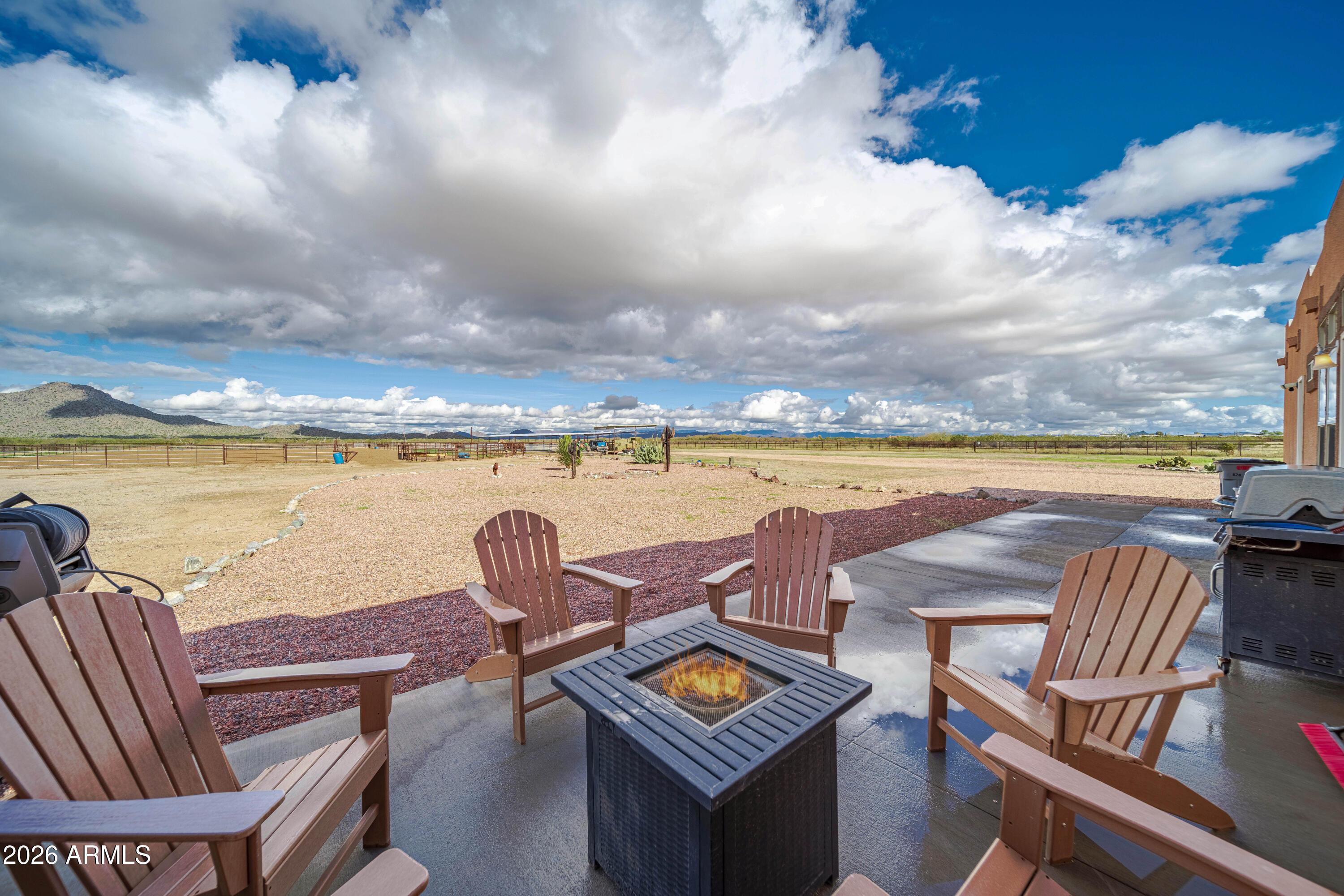 46109 West J-1 Ranch Road Wickenburg, AZ 85390 - Photo 26 of 32 a view of a terrace with lawn chairs and wooden floor