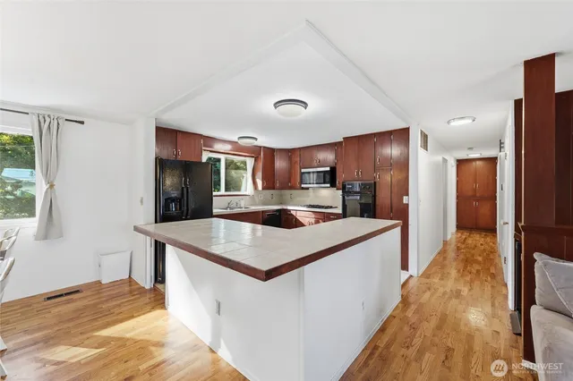 a kitchen with stainless steel appliances granite countertop a stove a refrigerator and a sink