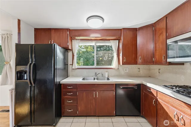 a kitchen with stainless steel appliances granite countertop wooden cabinets a stove top oven a sink and dishwasher