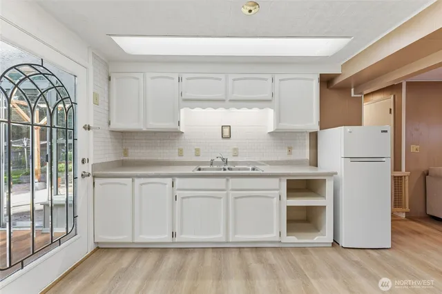a kitchen with a dining table chairs and white stainless steel appliances