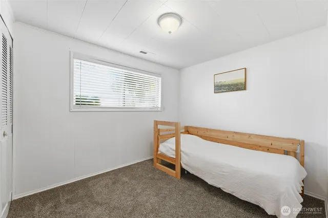 a bed sitting in a bedroom next to a window