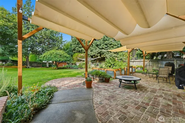 a view of a wooden house with a yard and sitting area