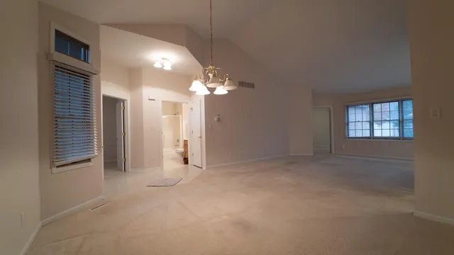 en empty room with windows and ceiling fan