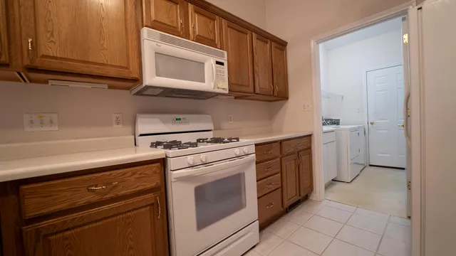 a kitchen with stainless steel appliances granite countertop white cabinets and a stove top oven
