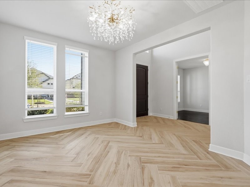 4710 Pecos Ridge Lane Sugar Land, TX 77479 - Photo 11 of 49 This bright room features large windows, elegant wood-patterned flooring, and a stunning crystal chandelier, creating a welcoming and sophisticated space.