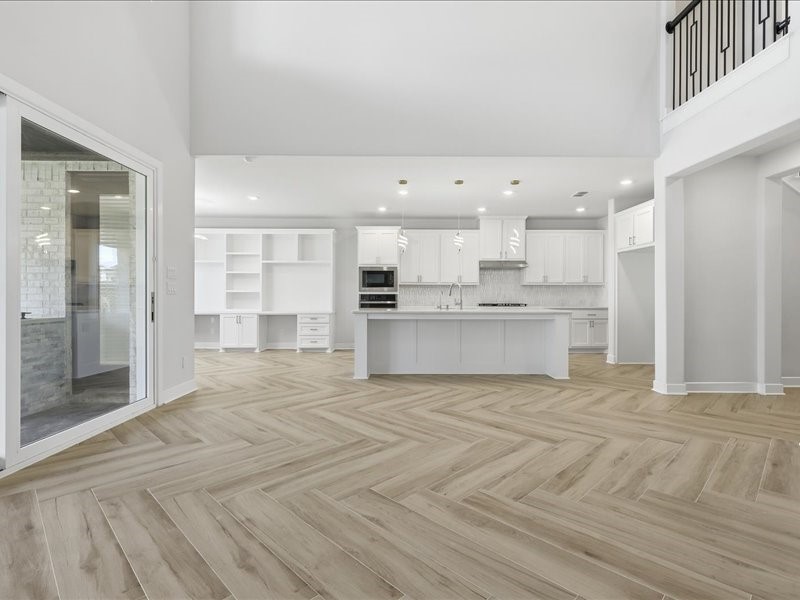 4710 Pecos Ridge Lane Sugar Land, TX 77479 - Photo 27 of 49 This modern home features an open-concept kitchen and living area with high ceilings and abundant natural light. It boasts elegant white cabinetry, a spacious island, and sleek hardwood flooring throughout.