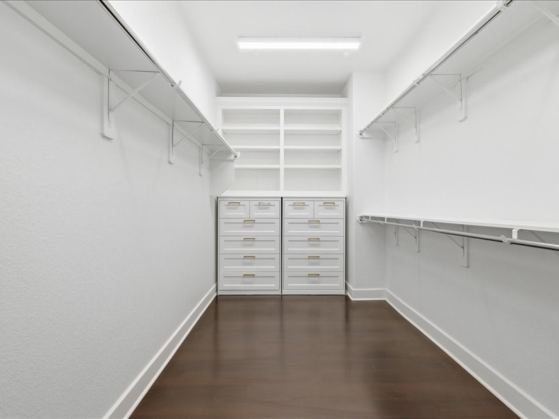 4710 Pecos Ridge Lane Sugar Land, TX 77479 - Photo 31 of 49 Spacious walk-in closet featuring ample shelving, hanging racks, and multiple drawers for organized storage. Bright lighting and a clean, modern design enhance functionality.