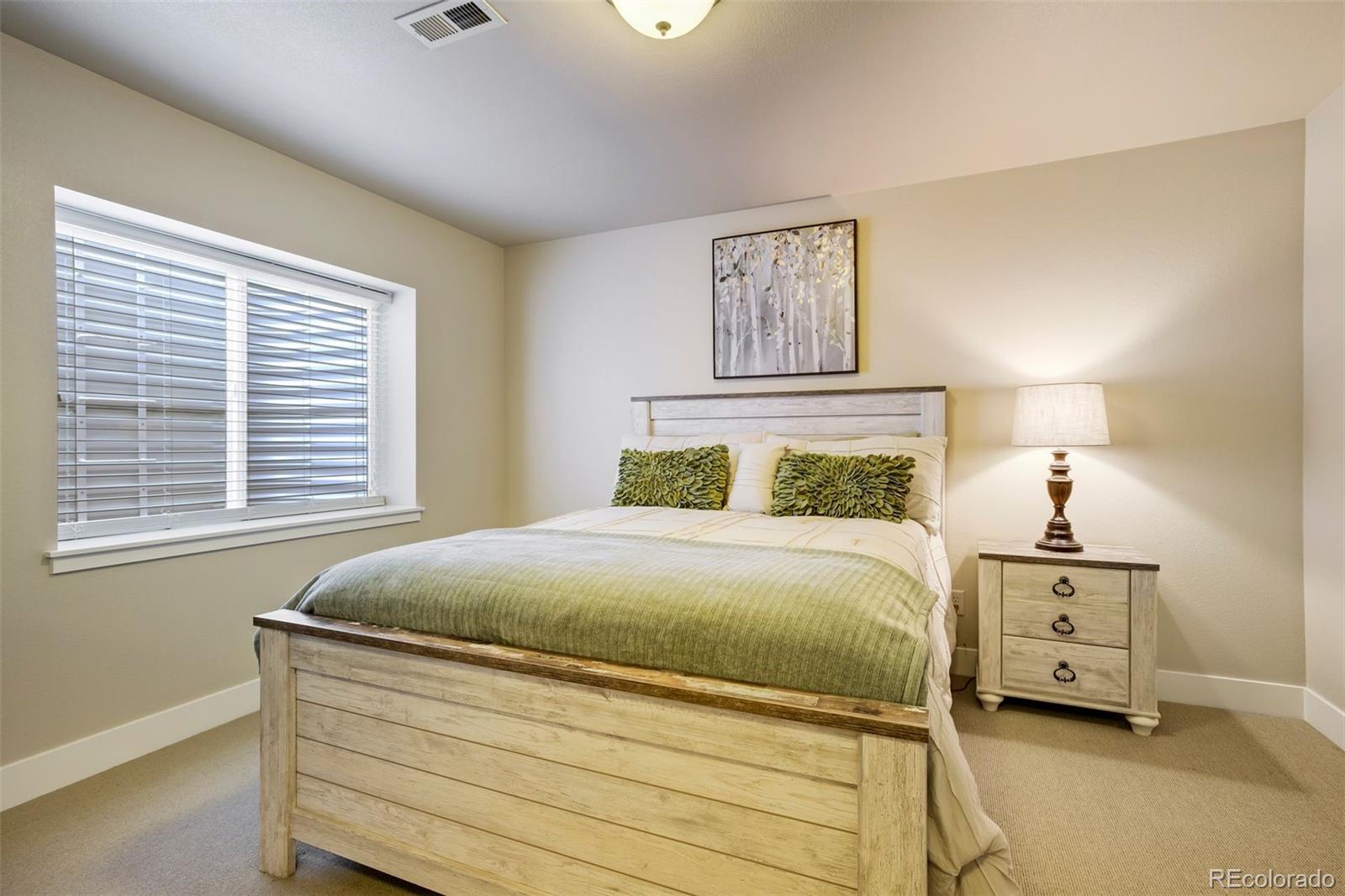 4970 Rabbit Mountain Court Colorado Springs, CO 80924 - Photo 33 of 50 a bedroom with a bed and a painting on the wall