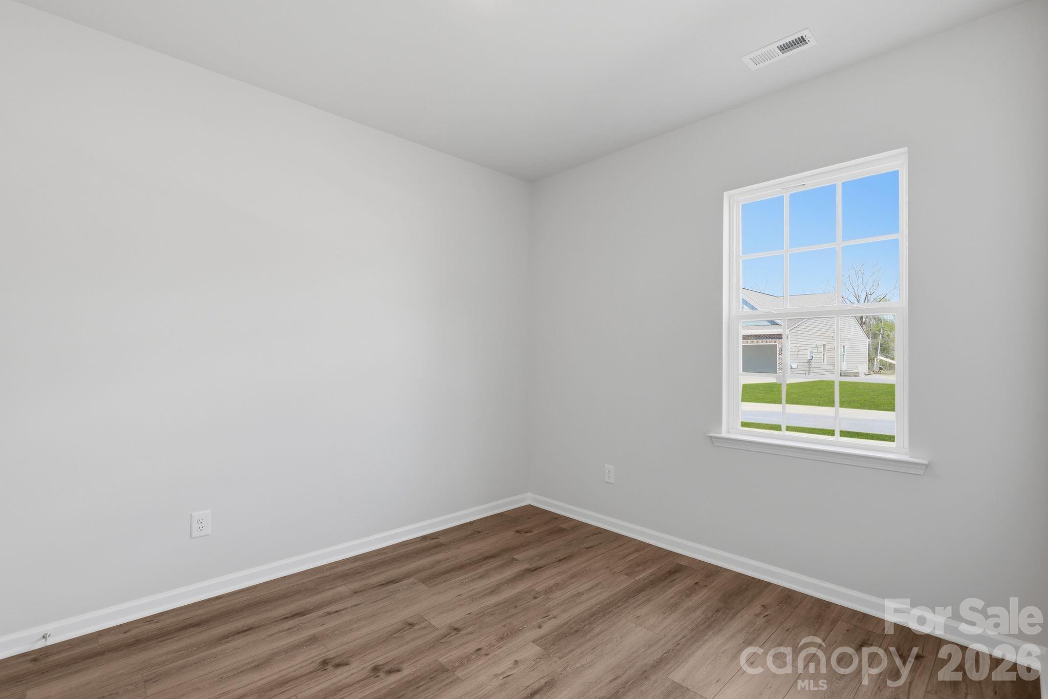 5475 Redbud Road, Unit 57 Lancaster, SC 29720 - Photo 6 of 30 a view of an empty room with wooden floor and a window