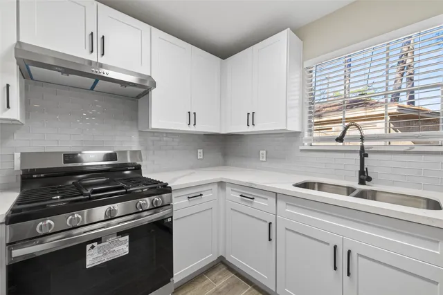an empty room with wooden floor ceiling fan and windows