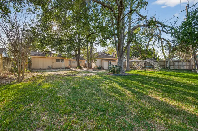a view of a backyard with wooden fence