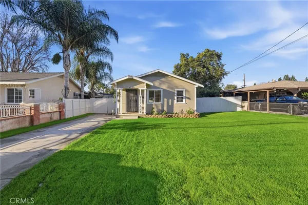 a front view of a house with a garden and yard