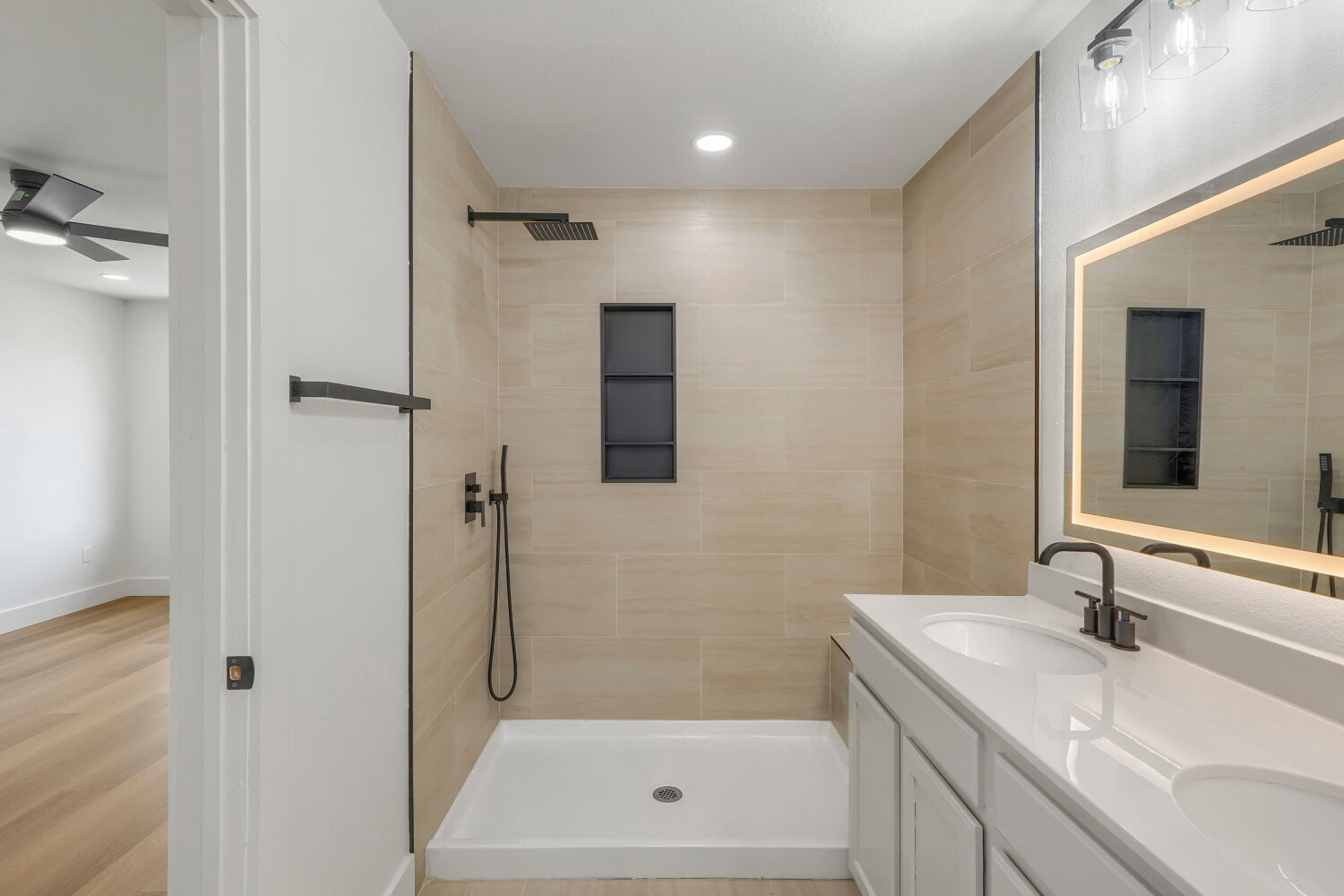 320 Triumph Road Buda, TX 78610 - Photo 12 of 22 Modern tile surrounds a spacious walk-in shower alongside a double vanity setup.