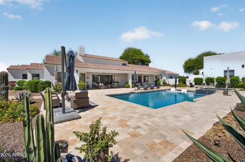 a view of a swimming pool with a table and chairs under an umbrella
