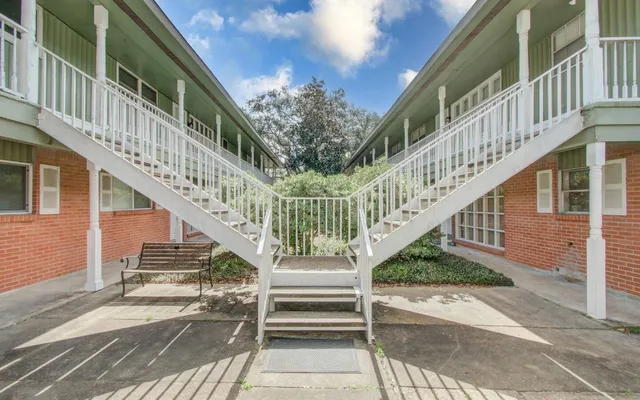 a view of staircase with lots of frames on wall and windows