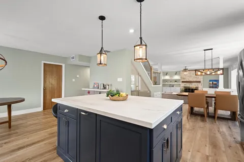 a kitchen that has a sink a stove and a table with chairs