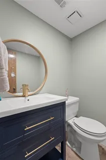 a bathroom with a toilet a sink and mirror
