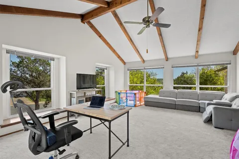 a living room with furniture a flat screen tv and a large window