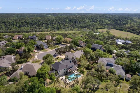 an aerial view of a house with a yard and lake view