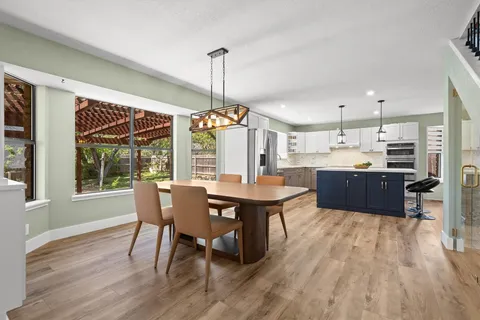 a view of a dining room with furniture large windows and wooden floor