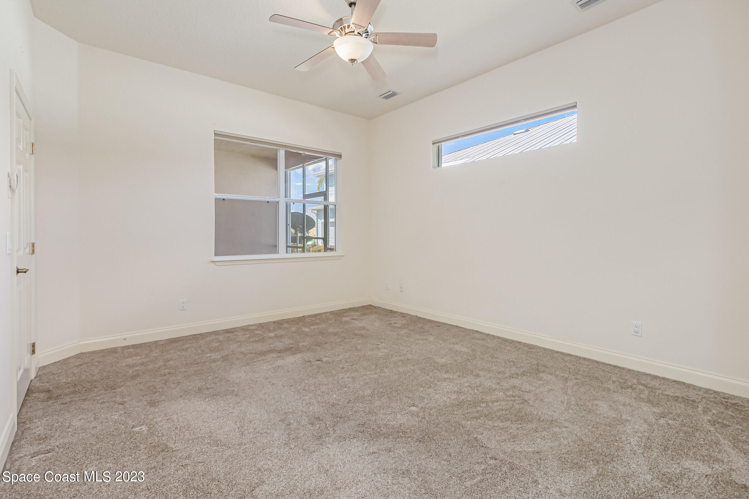 4100 Alamanda Key Drive Melbourne, FL 32901 - Photo 17 of 73 an empty room with a chandelier fan and windows