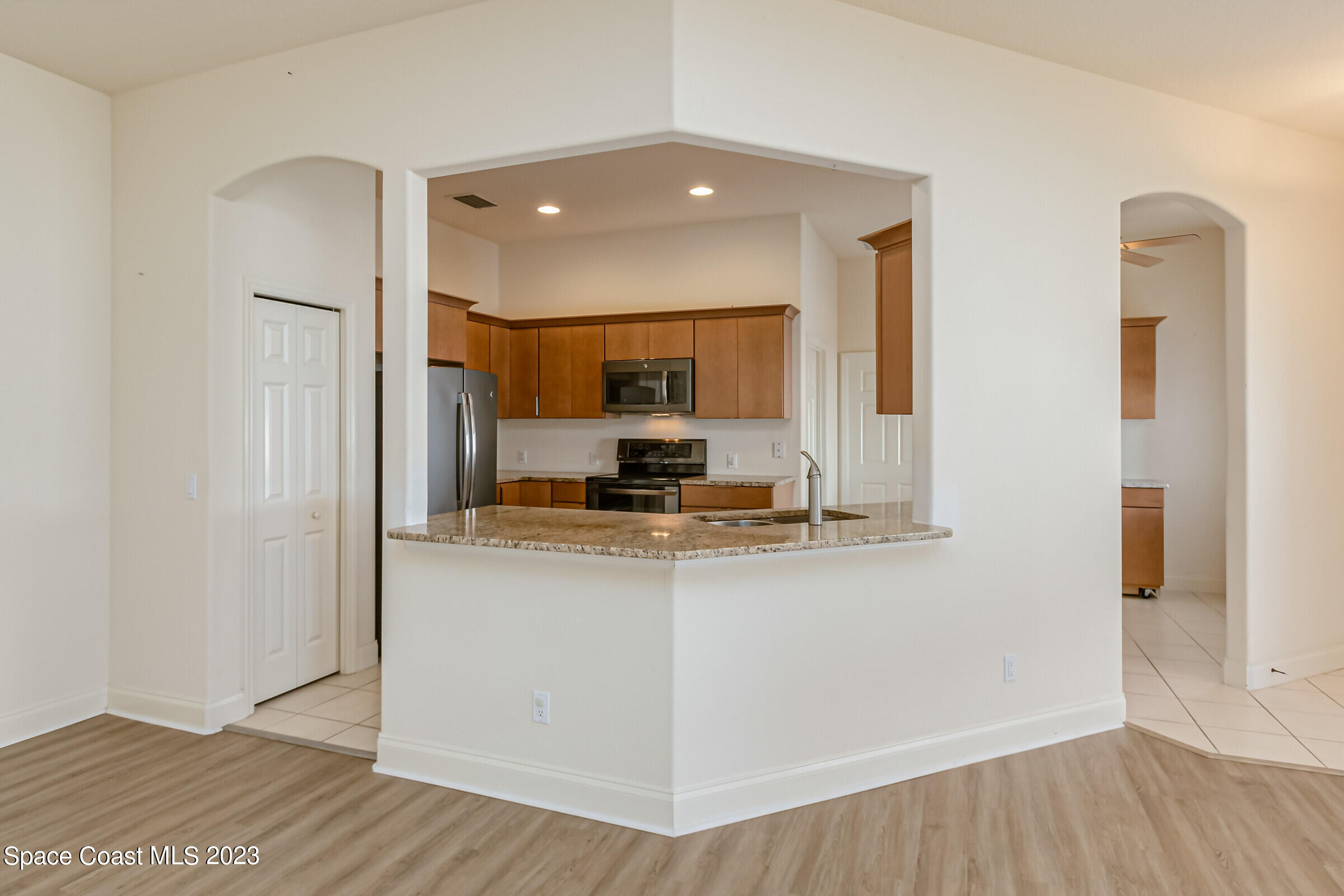 4100 Alamanda Key Drive Melbourne, FL 32901 - Photo 24 of 73 a kitchen with stainless steel appliances granite countertop a refrigerator and a stove top oven