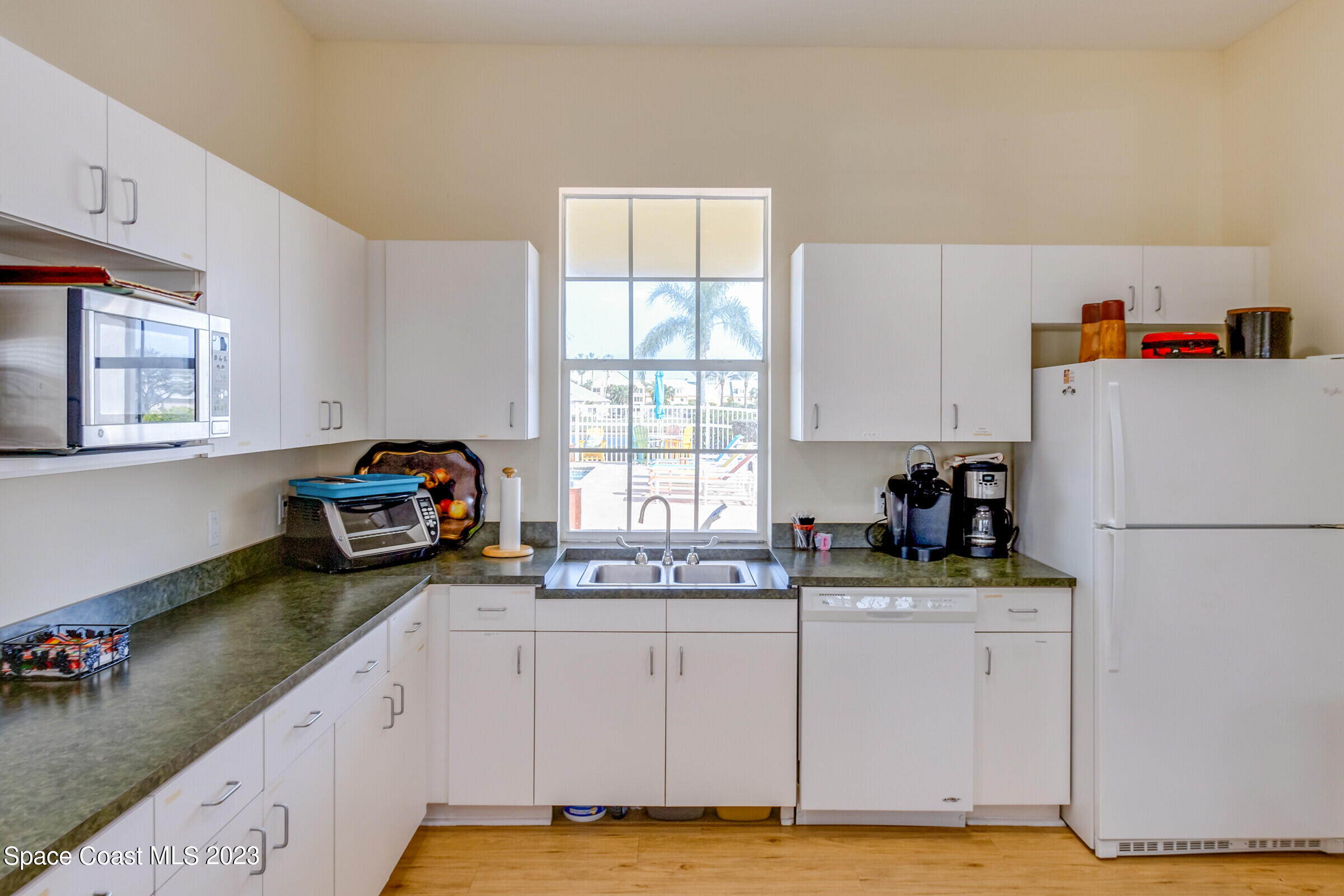 4100 Alamanda Key Drive Melbourne, FL 32901 - Photo 64 of 73 a kitchen with stainless steel appliances a sink a stove a refrigerator and cabinets