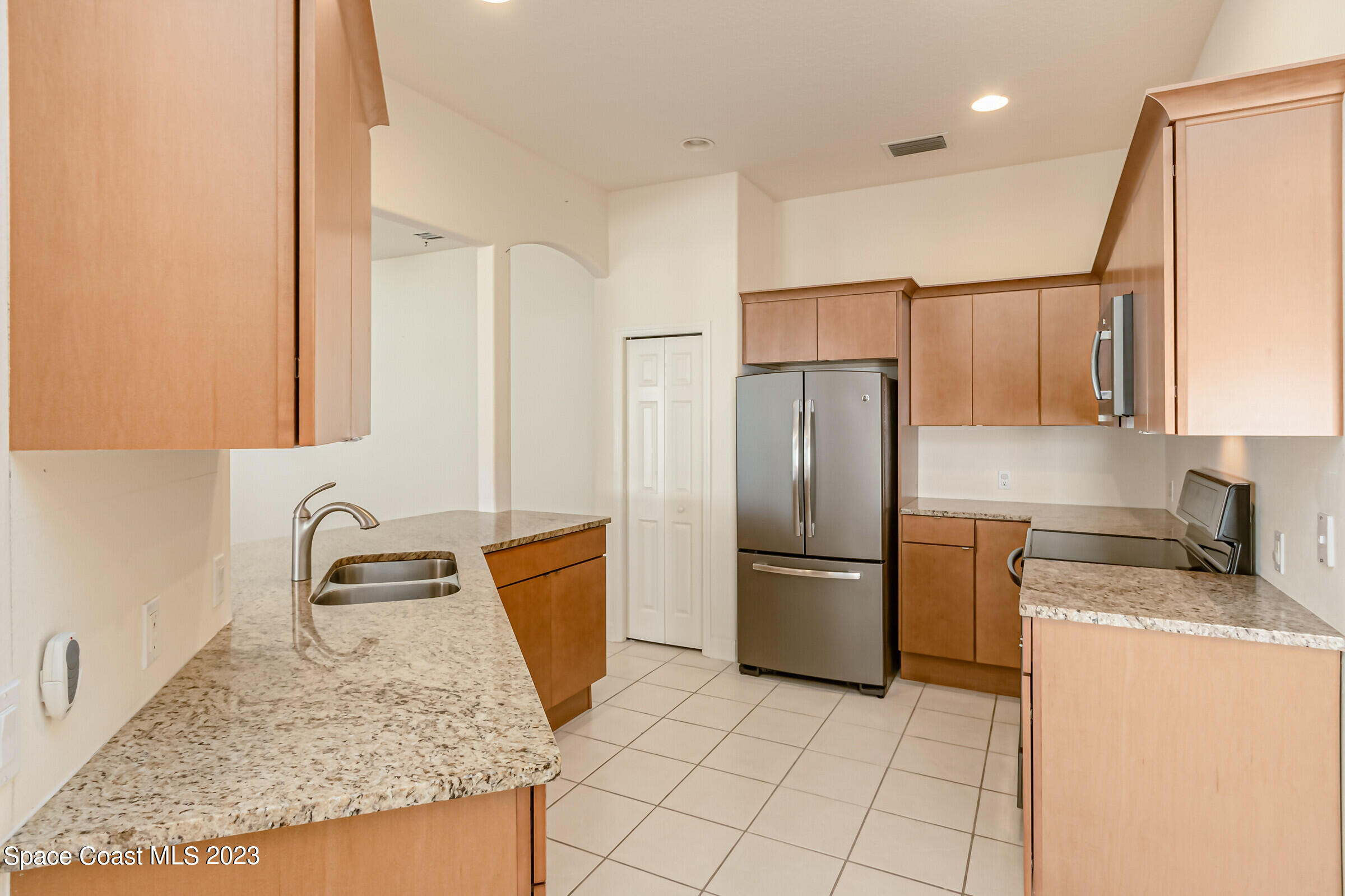 4100 Alamanda Key Drive Melbourne, FL 32901 - Photo 7 of 73 a kitchen with granite countertop a refrigerator and a sink