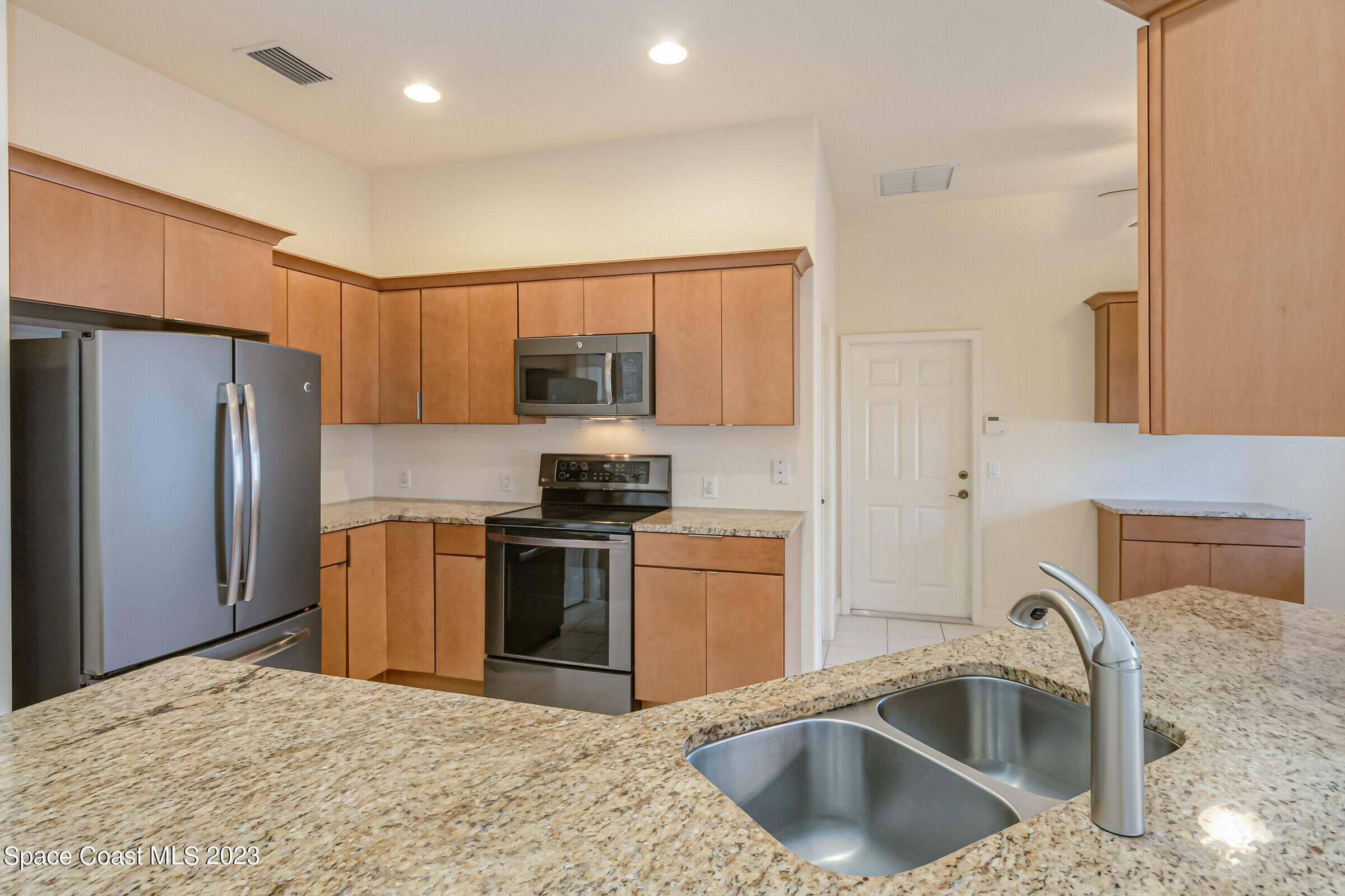 4100 Alamanda Key Drive Melbourne, FL 32901 - Photo 9 of 73 a kitchen with stainless steel appliances granite countertop a sink stove and refrigerator