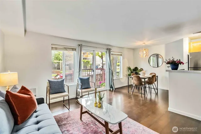 a living room with furniture a dining table and a large window with garden view