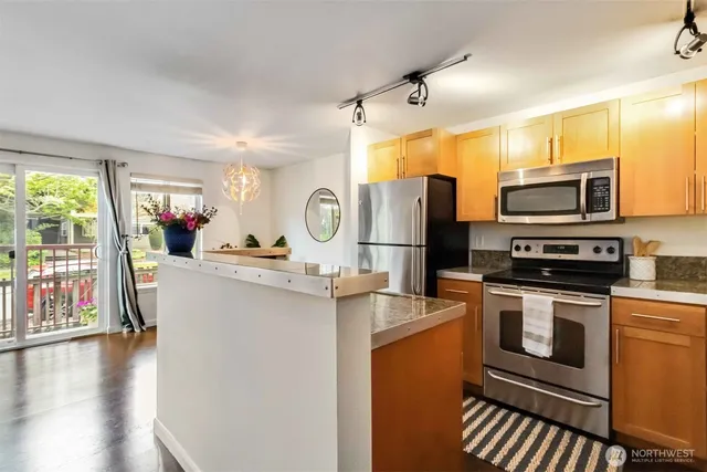 a kitchen with stainless steel appliances a stove refrigerator sink and microwave