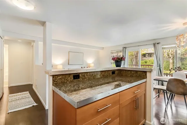 a view of kitchen island a sink wooden floor and living room view