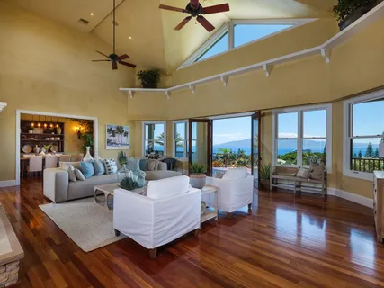 a view of a dining room and livingroom with furniture wooden floor a chandelier