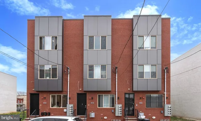 a front view of a residential apartment building with a yard