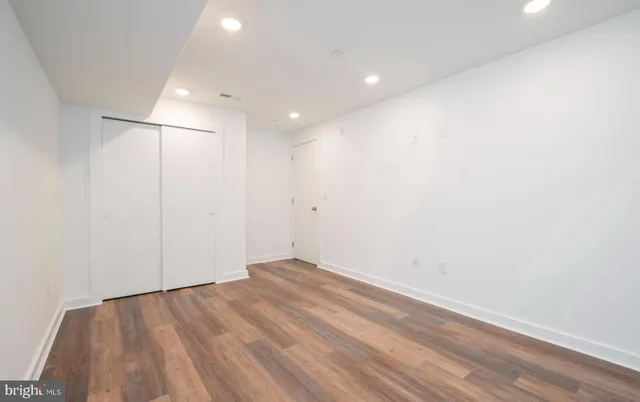 a view of a room with wooden floor and white walls