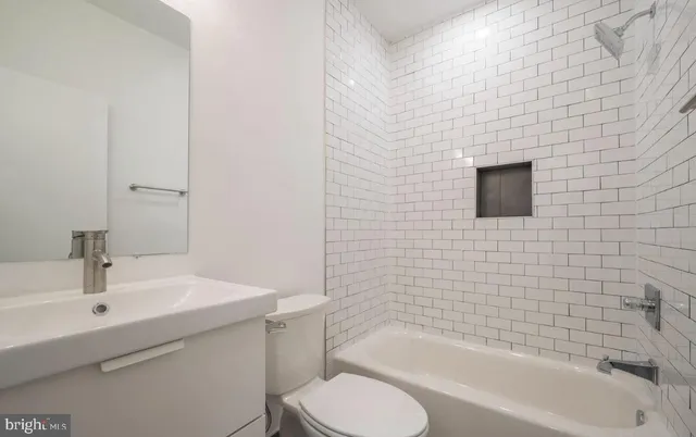 a white toilet sitting next to a bath tub