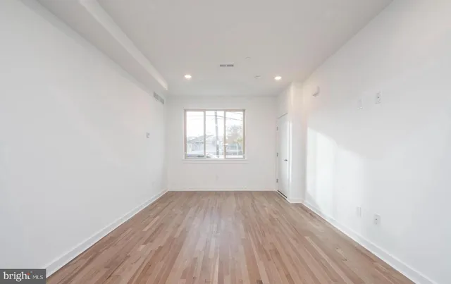 a view of a room with wooden floor and white walls