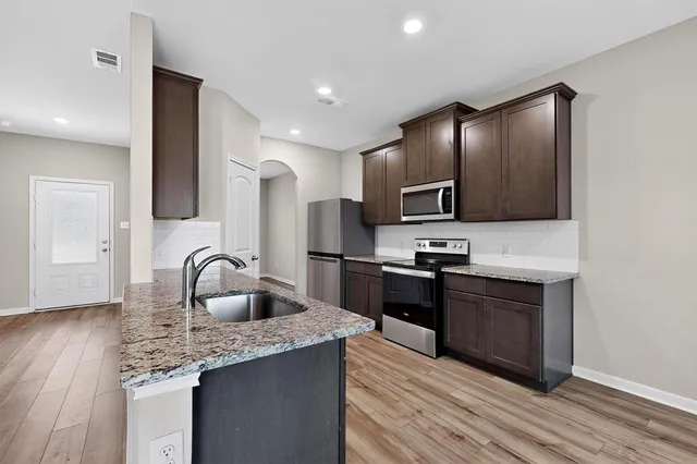 a kitchen with granite countertop stainless steel appliances and wooden cabinets