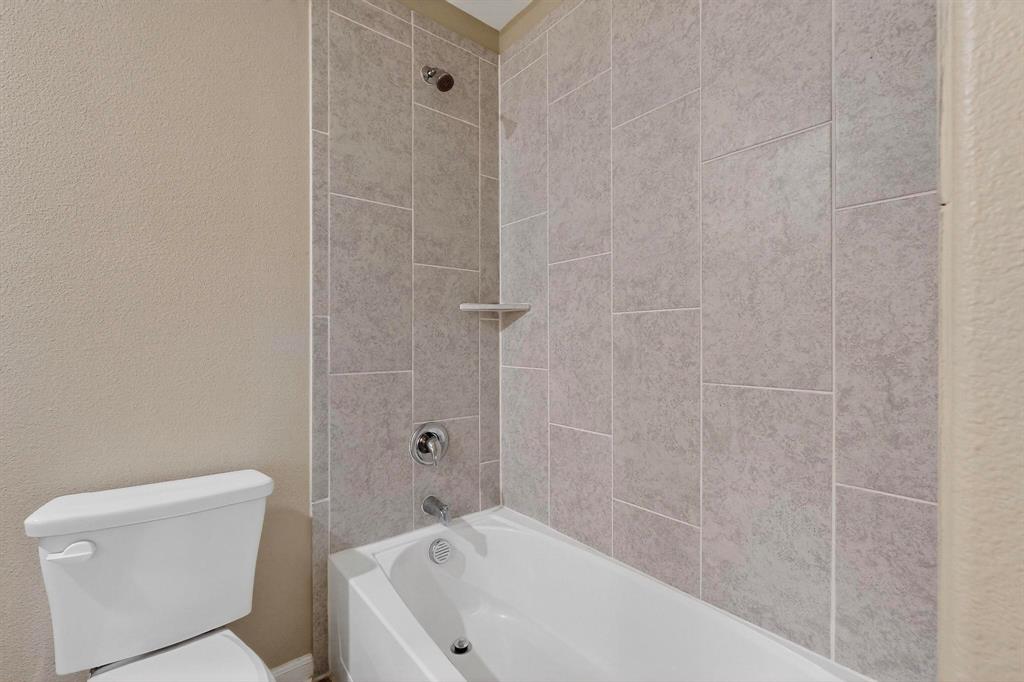 305 Honeysuckle Lane Princeton, TX 75407 - Photo 20 of 39 a bathroom with a bathtub and toilet