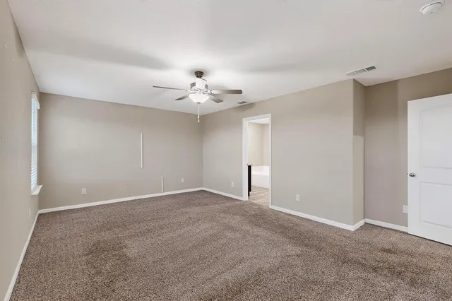 a view of an empty room with a chandelier fan